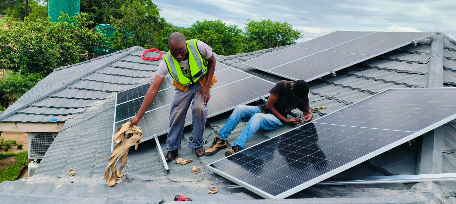Technicians installing solar panels on a rooftop